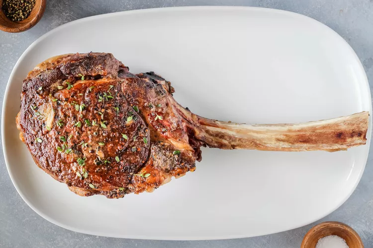 The tomahawk steak is a showstopper cut of beef, known for its impressive bone and rich flavor. This steak is essentially a ribeye with an extra-long bone left intact, giving it a distinctive appearance and a fantastic flavor profile. Often associated with high-end steakhouses and special occasions, the tomahawk steak is a treat for any meat lover.

To prepare a tomahawk steak, you’ll need to focus on the details to ensure it’s cooked to perfection. Whether you’re grilling, pan-searing, or finishing it in the oven, understanding how to properly season and cook this cut will elevate your dining experience. The following sections will guide you through each step of the process to make sure your tomahawk steak turns out juicy and flavorful.

Choosing the Perfect Tomahawk Steak

Selecting the right tomahawk steak is the first step towards a great meal. Look for a steak with a thick cut and well-marbled meat. The marbling is essential as it adds flavor and tenderness to the steak. A good tomahawk steak will have a pronounced, frenched bone, which is the part of the rib bone left exposed after the meat has been trimmed.

Ensure that the steak has a deep, red color with visible fat marbling throughout. Avoid steaks with dry or discolored patches. The size of a tomahawk steak can vary, but generally, it’s around 2 inches thick and can weigh between 2 to 3 pounds. If you’re buying from a butcher, don’t hesitate to ask for recommendations based on your cooking method and desired doneness.

Preparing and Seasoning Your Steak

Proper preparation is crucial for a tomahawk steak. Start by patting the steak dry with paper towels. This step is important as it helps achieve a good sear when cooking. Next, season the steak generously with salt and black pepper. The seasoning should be applied evenly on both sides.

For additional flavor, you can use garlic powder, onion powder, or a steak rub of your choice. Make sure to let the steak sit at room temperature for at least 30 minutes before cooking. This helps the steak cook more evenly. If you’re using a marinade, ensure the steak is marinated for several hours or overnight for the best flavor infusion.

Cooking Methods for Tomahawk Steak

Grilling Tomahawk Steak

Grilling is one of the most popular methods for cooking a tomahawk steak. Preheat your grill to high heat, aiming for around 500°F (260°C). Sear the steak for about 2-3 minutes on each side to develop a nice char. Once seared, move the steak to a cooler part of the grill or lower the heat to cook it to your desired doneness. Use a meat thermometer to check the internal temperature, aiming for 130-135°F (54-57°C) for medium-rare.

Pan-Seared Tomahawk Steak

Pan-searing a tomahawk steak is another excellent method. Heat a cast-iron skillet over high heat with a small amount of oil. Once the pan is hot, add the steak and sear for about 2-3 minutes on each side. After searing, reduce the heat and cook the steak to your preferred doneness, using a meat thermometer to ensure accuracy. You can also add butter, garlic, and herbs to the pan for extra flavor.

Oven-Finished Tomahawk Steak

If you prefer to finish your steak in the oven, start by searing it in a hot skillet as described above. After searing, transfer the skillet to a preheated oven set to 400°F (200°C). Cook the steak in the oven until it reaches your desired internal temperature. This method helps cook the steak evenly and is especially useful for thicker cuts.

Tips for Achieving the Perfect Doneness

Achieving the perfect doneness for your tomahawk steak involves monitoring the internal temperature closely. Use a reliable meat thermometer to check the steak's temperature. Here’s a quick guide:

Rare: 120-125°F (49-52°C)

Medium-Rare: 130-135°F (54-57°C)

Medium: 140-145°F (60-63°C)

Medium-Well: 150-155°F (66-68°C)

Well-Done: 160°F (71°C) and above

Remember that the steak will continue to cook slightly after being removed from the heat, so take it off the grill or out of the oven a few degrees before it reaches your target temperature.

Letting Your Steak Rest

Resting is a crucial step in preparing a tomahawk steak. After cooking, let the steak rest on a cutting board for 10 minutes. This allows the juices to redistribute throughout the meat, ensuring a more flavorful and tender steak. Avoid covering the steak with foil, as this can cause the crust to become soggy. Simply let it rest uncovered in a warm area.

Serving and Enjoying Your Tomahawk Steak

Once your steak has rested, it’s time to serve. Slice the tomahawk steak against the grain to maximize tenderness. Serve it with your favorite sides and sauces. A tomahawk steak pairs well with classic steakhouse sides like mashed potatoes, grilled vegetables, or a fresh salad. Enjoy this impressive cut of meat and savor the rich flavors and tender texture.